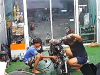 Nhân viên hốt hoảng khi xe máy bốc cháy trong lúc sửa chữa