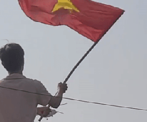 Nam thanh niên đứng trên mái nhà, vẫy cờ chào trực thăng gây bão mạng