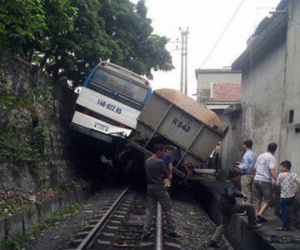 Tàu hỏa chèn xe khác chở công nhân 'lơ lửng' trên sườn đồi