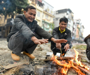 Người dân Hà Nội đốt củi sưởi ấm trên đường trong ngày mưa rét
