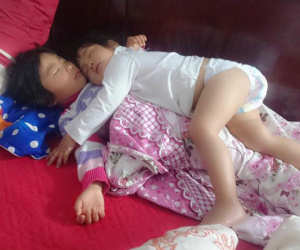 Khoảnh khắc 3 giờ sáng, hai con trứng gà trứng vịt nằm chồng lên nhau ngủ khiến trái tim ông bố đi làm về muộn tan chảy