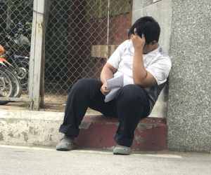 Làm bài thi kém, nam sinh ngồi ủ rũ trước cổng trường