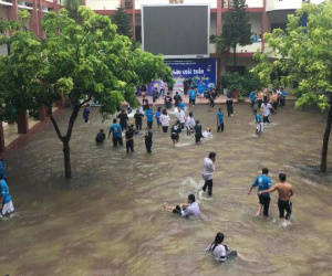 Chùm ảnh: Học sinh, sinh viên thích thú tắm mưa, tạt nước tưng bừng khi sân trường ngập lụt