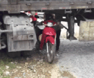 Ôtô đầu kéo mắc kẹt ngang đường, dân chui qua gầm để di chuyển