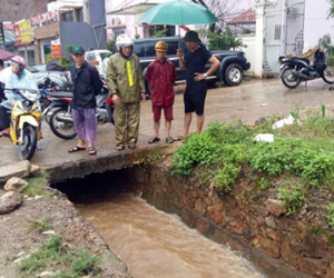Bé trai đi xe đạp điện ngã xuống cống bị nước cuốn trôi
