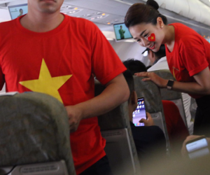 Tiếp viên Vietnam Airlines mặc áo phông in hình cờ đỏ sao vàng trên chuyên cơ đón đoàn Olympic Việt Nam về nước
