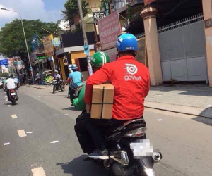 Thanh niên áo xanh GrabBike đèo bạn áo đỏ Go Việt, đội mũ Uber là hình ảnh 'ấm áp' nhất MXH hôm nay