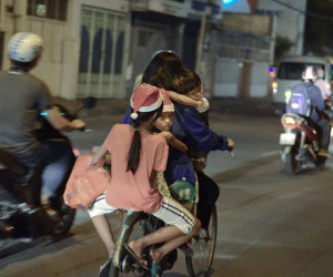 Khoảnh khắc lay động: Giáng sinh về sớm trên mái đầu trẻ thơ, mẹ chở 3 con trên chiếc xe đạp cũ