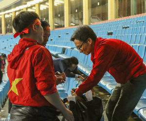 Phó thủ tướng Vũ Đức Đam nán lại cùng một số CĐV dọn rác trên sân Mỹ Đình sau chiến thắng của ĐT Việt Nam