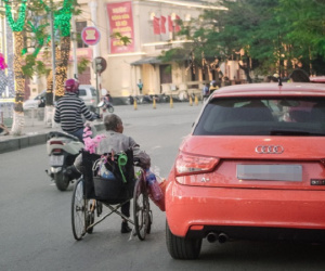 Cành đào phía sau xe lăn của ông cụ khiến dòng người vội vã ngày Tết như chậm lại