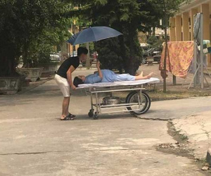 Vợ bụng bầu che ô cho chồng loay hay đẩy xe vào phòng sinh