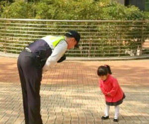 Bé gái hàng sáng chờ để chào viên cảnh sát