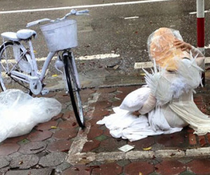 Cô gái mặc áo dài trắng, đeo cánh thiên thần nằm trên hè phố Hà Nội gây tò mò