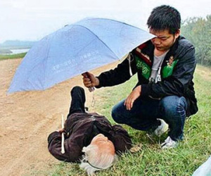 Chàng trai đứng trong mưa che ô cho bà lão 97 tuổi suốt 2 giờ
