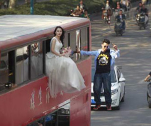 Cô gái mặc váy cưới treo mình lơ lửng trên xe buýt