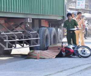 Chồng ngây dại bên thi thể vợ bị xe container cán chết