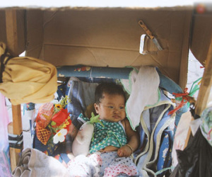 Bé gái 3 tháng tuổi nằm nôi theo bà ngoại rong ruổi khắp nơi bán vé số