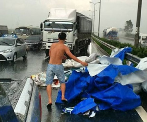 Người đàn ông dẹp biển quảng cáo bị đổ giữa cơn dông