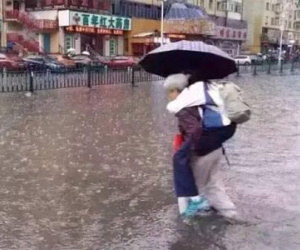 Bức ảnh bà lội nước cõng cháu gái lớn bổng đi học khiến dư luận dậy sóng