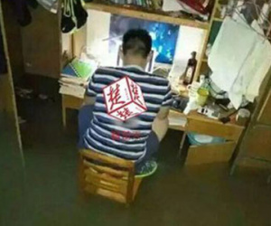 Nam sinh Trung Quốc được ca ngợi vì ngồi học giữa phòng ngập lụt