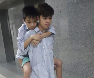 Đau lòng cảnh hai anh em mồ côi cha cõng nhau đi viện