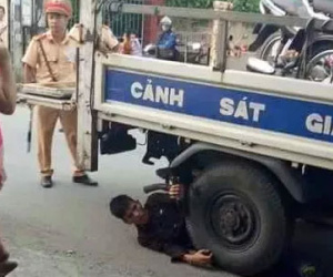 Nam thanh niên nằm ôm bánh xe ô tô của CSGT để "ăn vạ"