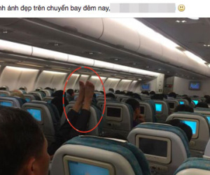 Người đàn ông gác chân lên ghế phía trước trên chuyến bay của VNA