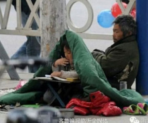 Em bé 6 tuổi vừa ăn xin vừa học bài trên vỉa hè