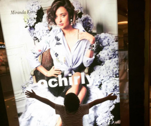 Con trai ôm chầm poster chân dung Miranda Kerr ở trung tâm thương mại