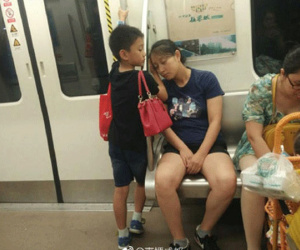 Cậu bé đứng kê tay cho mẹ ngủ ngon trên tàu điện ngầm