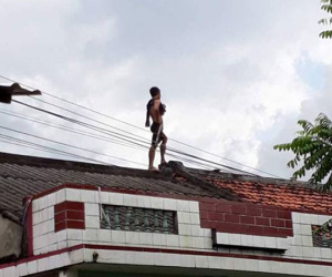 Nam thanh niên trèo lên nóc nhà dân ngồi hát nghêu ngao