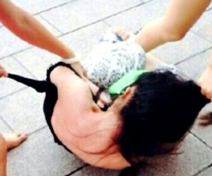 Ba mẹ con cùng lột quần áo một phụ nữ giữa chốn đông người