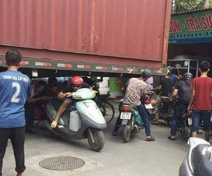 Bất chấp nguy hiểm, người dân thi nhau chui gầm container chắn ngang giữa đường để lưu thông
