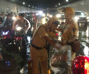 Trời bất ngờ đổ mưa giữa đêm Trung thu, 2 CSGT phát áo mưa miễn phí cho người dân trong hầm Thủ Thiêm