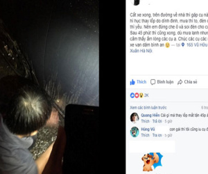 Chàng trai cầm ô che cho bác tài xế thay lốp ôtô giữa cơn mưa lớn