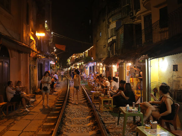 Hà Nội: Bất chấp nguy hiểm, khách du lịch vẫn thản nhiên chụp ảnh, ăn uống ngay sát đường ray tàu