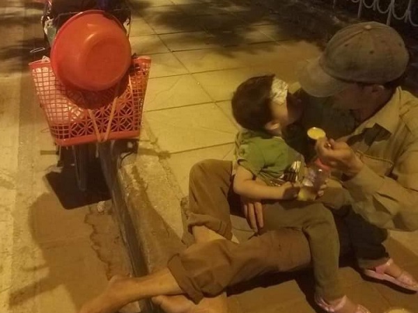 Hình ảnh người đàn ông lấm lem ngồi bên vỉa hè đút cháo cho con nhỏ và câu chuyện không thể ngờ phía sau