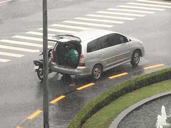 Ô tô 7 chỗ dừng bên góc đường, mở cửa để tài xế xe ôm kịp ngồi trú mưa khiến nhiều người cảm thấy ấm lòng