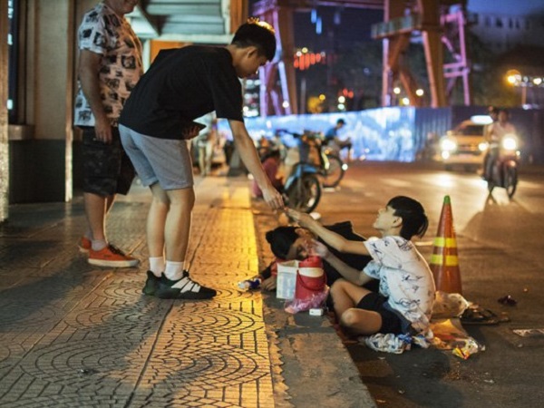 Mẹ ngủ gục ngay trên nền bê tông, dân mạng xúc động vì hành động của bé trai