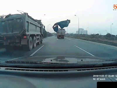 Video: Tấm bạt phủ trên xe tải bất ngờ bay, phủ kín đầu xe phía sau khiến tài xế thót tim