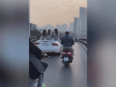 Video: Ngồi lên thành xe thả tờ rơi, nhóm cô gái bị 'ném đá' dữ dội