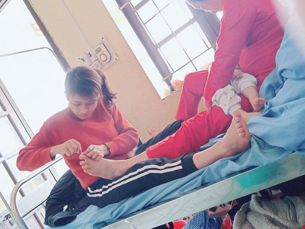 Hình ảnh con dâu cần mẫn ngồi cắt móng chân cho mẹ chồng trên giường bệnh khiến nhiều người xúc động