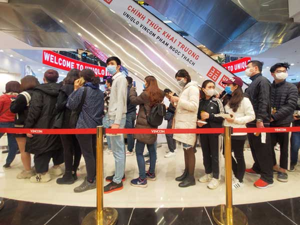 Hàng trăm khách đeo khẩu trang xếp hàng chờ mua sắm ở cửa hàng Uniqlo đầu tiên tại Hà Nội