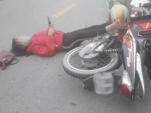 Sau va chạm giao thông, đôi nam nữ nằm sõng soài ra đường rồi lôi điện thoại ra bấm