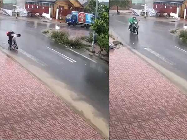 Dừng xe đạp giữa trời mưa, cậu học sinh nhỏ dùng tay thông cống thoát nước công cộng