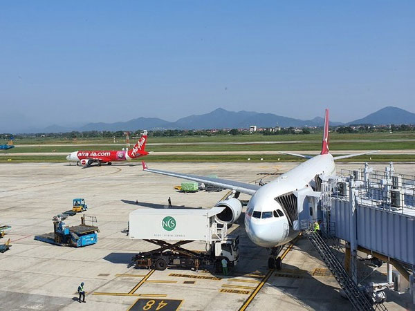 Lái xe chạy qua đuôi máy bay đang lùi trong sân bay Nội Bài