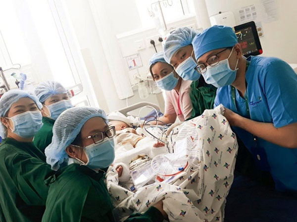 2 bé song sinh Diệu Nhi - Trúc Nhi đã bớt sốt, các bác sĩ tiến hành chuyển bé qua nệm chống loét, nhiễm trùng