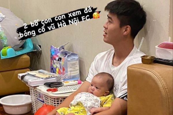 Duy Mạnh vừa bế con vừa cổ vũ Hà Nội FC, bé Ú nhoẻn miệng cười đốn tim dân mạng