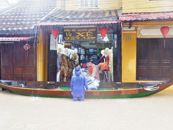Ảnh: Người dân Hội An hối hả dọn đồ chạy lũ, du khách thích thú lội nước chụp ảnh giữa trời mưa