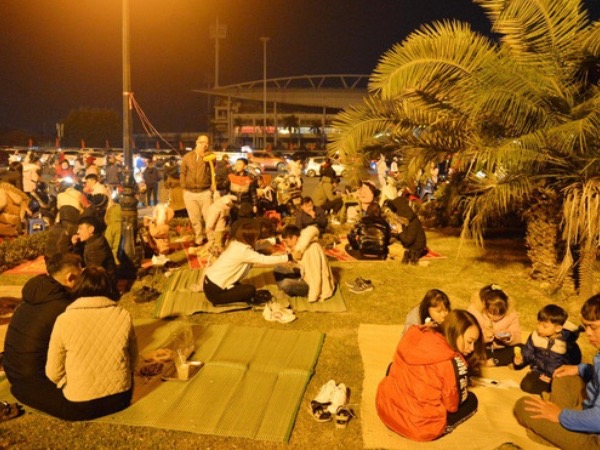 Người dân Hà Nội trải chiếu, ngồi la liệt trên bãi cỏ uống nước, cắn hướng dương 'canh' pháo hoa đón năm mới 2021